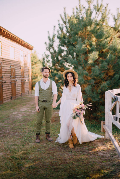 boho-style newlyweds walk on ranch, summer day - Foto, Bild