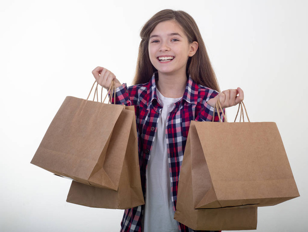Menina feliz segurando sacos de compras em suas mãos
.   - Foto, Imagem