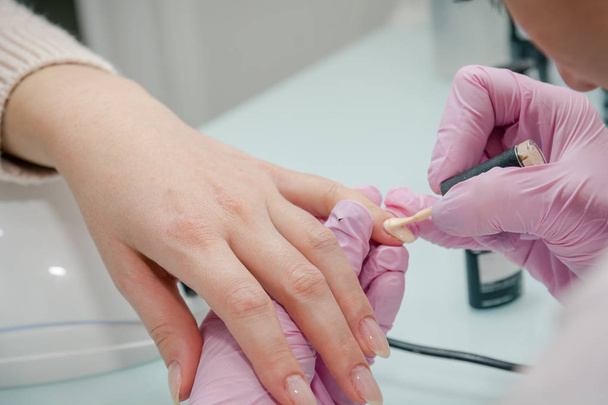 Putting varnish on nails. Processing of nails in beauty shop. To paint nails in beauty shop. - Photo, Image