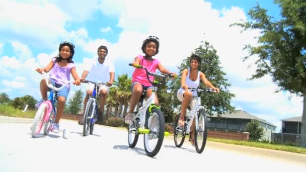 νεαρή εθνοτικής οικογένεια απολαμβάνοντας την ποδηλασία μαζί - Πλάνα, βίντεο
