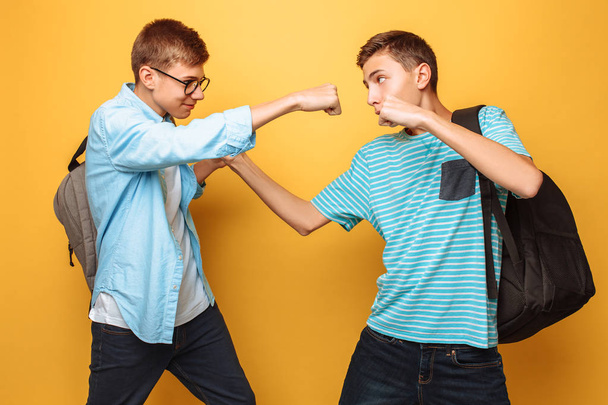 Serious opponents, two teenagers, guys show fists, ready for battle, have strict facial expressions - Foto, afbeelding