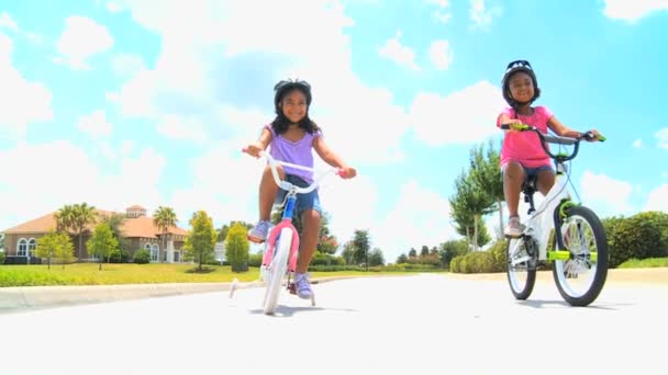 dwóch młodych sióstr etniczne jazda ich rowery - Materiał filmowy, wideo