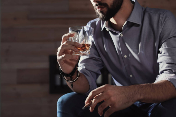 Man with glass of whiskey and cigar at home, closeup. Space for text - Fotografie, Obrázek