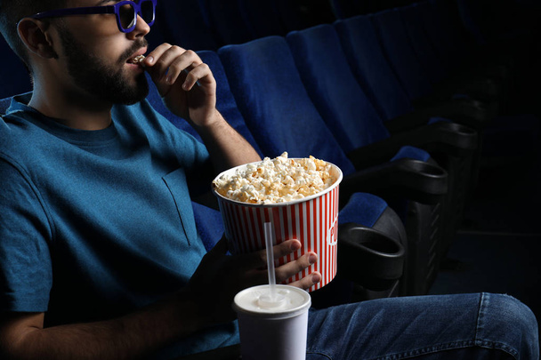 Young man with popcorn watching movie in cinema, closeup - Photo, Image