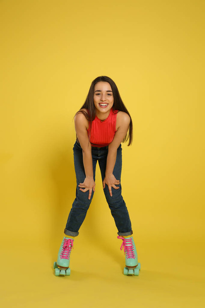 Young woman with roller skates on color background - Foto, immagini