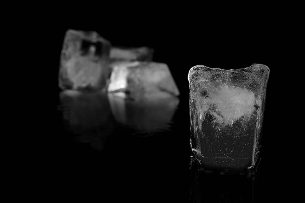 Transparent ice cube on black mirror surface - Foto, imagen