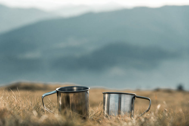 metal cups on a background of mountains - Photo, Image