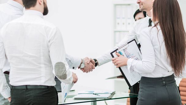 handshake of business partners on background of office workers - Fotó, kép