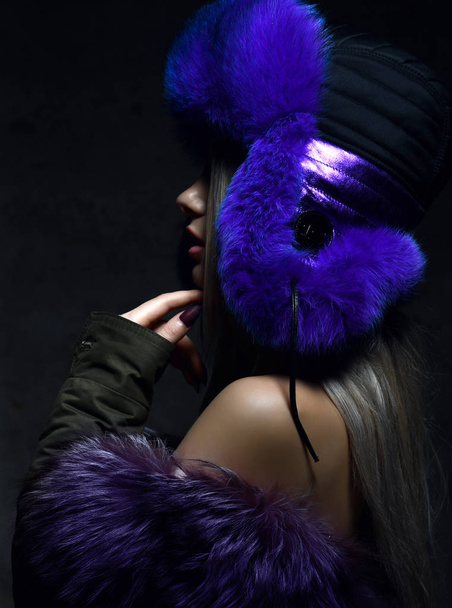 Portrait of young beautiful woman in blue purple fashion arctic fox winter fur ear flap hat  - Foto, imagen