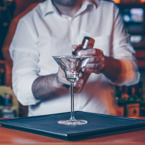 Barman sirviendo cóctel en un club nocturno. Vida nocturna y concepto de entretenimiento. Cuadrado
 - Foto, imagen