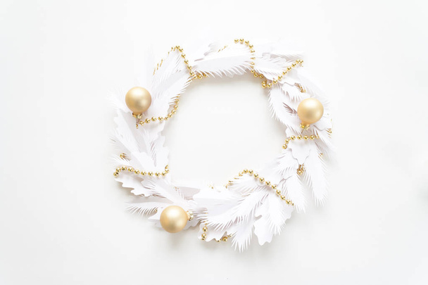 Merry Christmas and Happy New Year. Christmas wreath with gold garland and gold balls made of white paper - Photo, Image