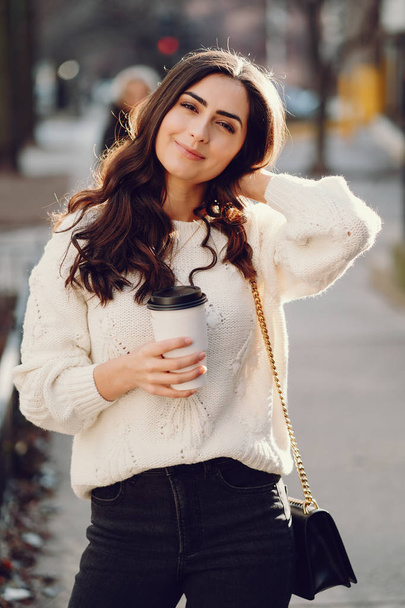 Cute brunette in a white sweater in a city - Photo, image