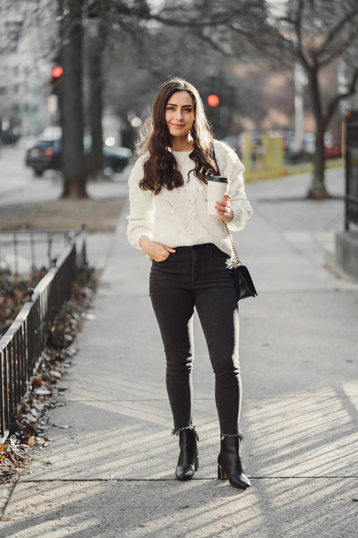 Cute brunette in a white sweater in a city - Foto, imagen