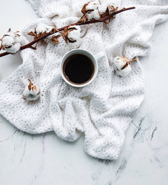 Шарф, чашка кофе и хлопковые цветы на мраморном фоне
 - Фото, изображение