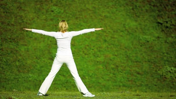 kobieta w bieli relaks z jogi na świeżym powietrzu - Materiał filmowy, wideo