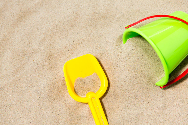 close up of toy bucket and shovel on beach sand - Fotó, kép