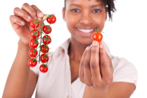 junge glückliche schwarzafrikanische Amerikanerin hält Tomaten in der Hand - Foto, Bild