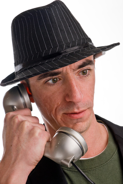 Headshot de homem caucasiano vestindo um chapéu estilo fedora e falando ao telefone
 - Foto, Imagem