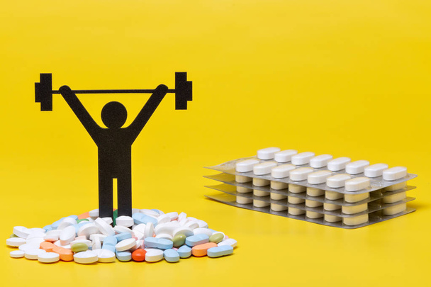 súlyemelés piktogram tabletták, sárga háttérrel - Fotó, kép