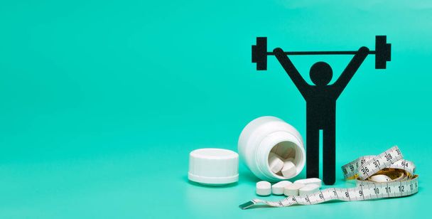 weightlifting pictogram with pills, tape measure and bright green background - Photo, Image