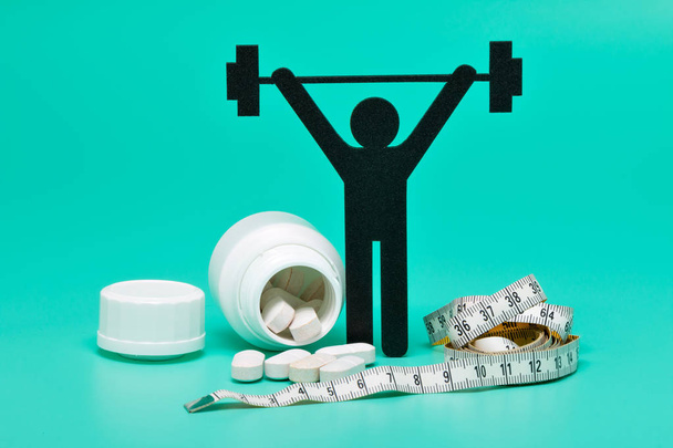 Gewichtheffen pictogram met pillen, meetlint en helder groene achtergrond - Foto, afbeelding