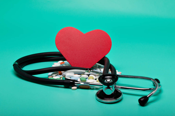 Corazón rojo con diferentes píldoras un estetoscopio
 - Foto, imagen
