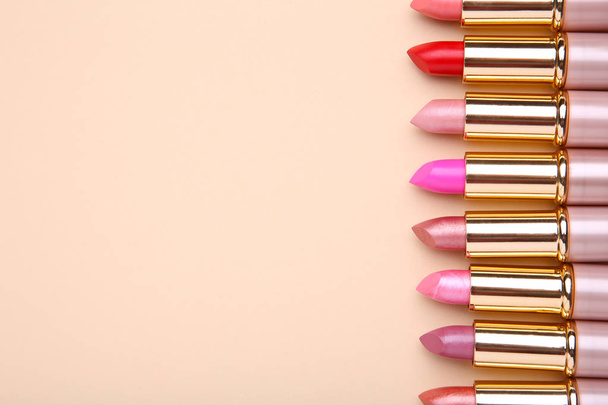 Many colorful lipstick on beige background. Cosmetic - 写真・画像
