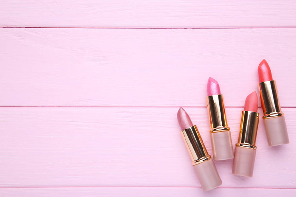 Many pink lipsticks on pink background. Cosmetic - Zdjęcie, obraz