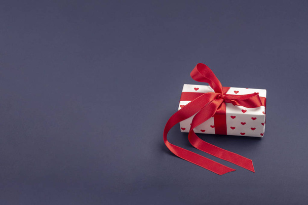 Подарок, завернутый в красную коробку с изображением сердца на День Святого Валентина. Изолировать на белом фоне с тенью
 - Фото, изображение