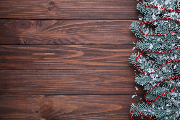 Karácsonyi dekoráció. Fenyő fa ág gyöngyökkel barna fa háttér. - Fotó, kép