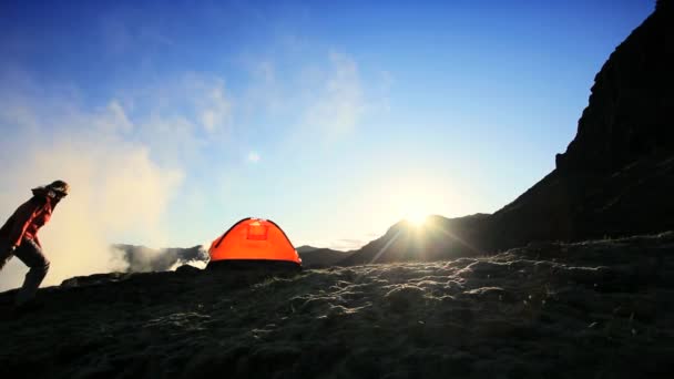 samotny turysta przez namiot na śniegu objętych skał - Materiał filmowy, wideo