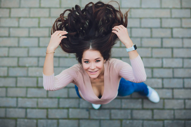 Young smiling teen girl looking camera. Shot from above. - 写真・画像
