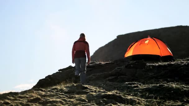 kobieta wycieczkowicz przez namiot na zboczu góry jałowe - Materiał filmowy, wideo