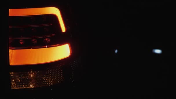 Farol traseiro do automóvel pisca no fundo escuro
 - Filmagem, Vídeo