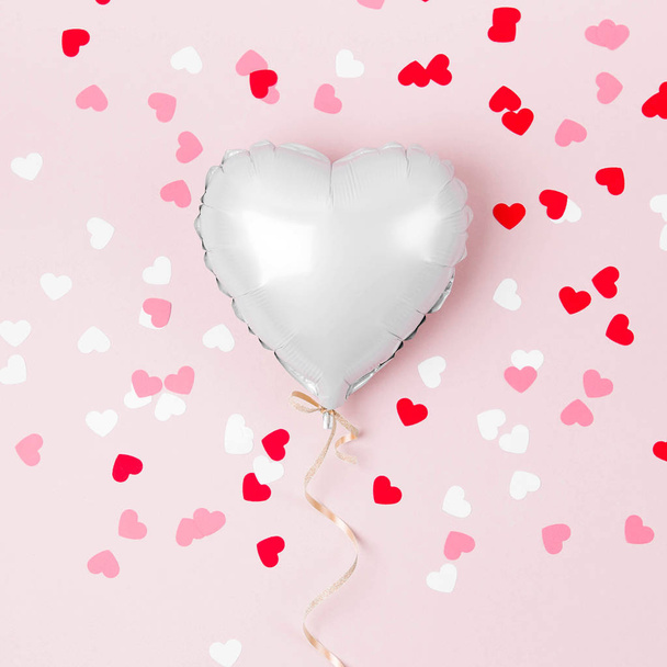 Single Balloon of heart shaped foil on pastel pink background. Love concept. Holiday celebration. Valentine's Day or wedding/bachelorette party decoration. Metallic balloon - Фото, изображение