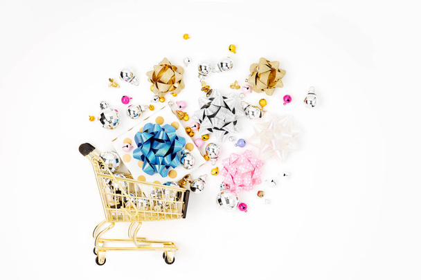 Shiny gifts with  bows in a shopping cart on a white background.  Shopping concept. Flat lay, top view - Foto, immagini