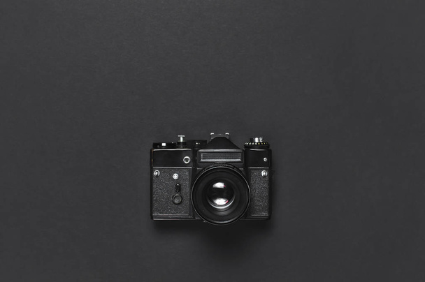 Vanha retro vintage kamera musta tausta ylhäältä katsottuna tasainen makasi kopioi tilaa. Konsepti valokuvaaja, vanhat valokuvauslaitteet minimalistinen tyyli valikoiva keskittyä
 - Valokuva, kuva