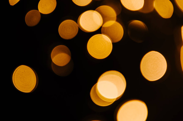 Abstract Gold bokeh sparkle on black background. Lights blurred bokeh  for christmas design - Фото, зображення