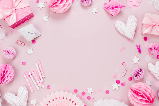 Frame made of Pink and white Paper Decorations, candy, hearts, gifts, confetti for Baby party. Flat lay, top view - Photo, image