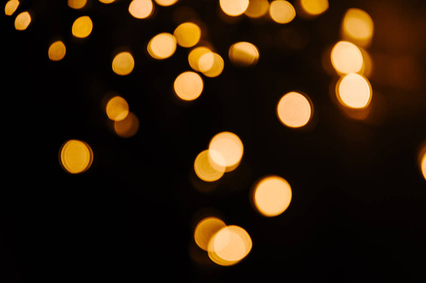 Abstract Gold bokeh sparkle on black background. Lights blurred bokeh  for christmas design - Photo, Image