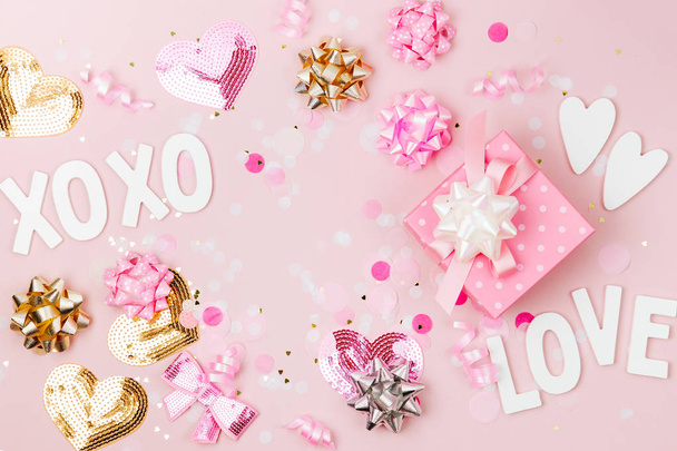 Gift with Confetti, bows and paper decorations. Valentines day or birthday party concept theme. Flat lay, top view - Foto, imagen