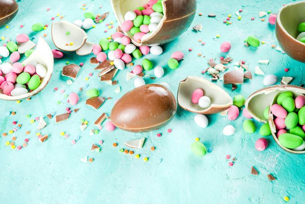 Барвистий весняний фон великодніх цукерок, з шоколадними яйцями, цукровими зморшками та зефірним кроликом, бірюзовий світло-блакитний бетонний фон копіювання простору зверху
 - Фото, зображення