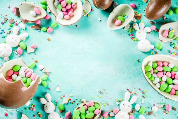 Барвистий весняний фон великодніх цукерок, з шоколадними яйцями, цукровими зморшками та зефірним кроликом, бірюзовий світло-блакитний бетонний фон копіювання простору зверху
 - Фото, зображення