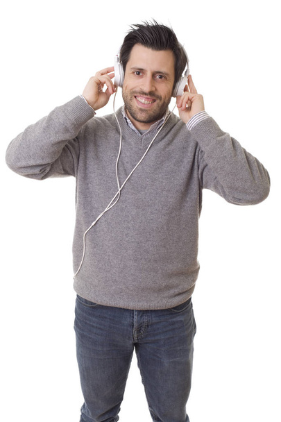 Zwykły młodzieniec słuchający muzyki ze słuchawkami, odizolowany na białym tle - Zdjęcie, obraz