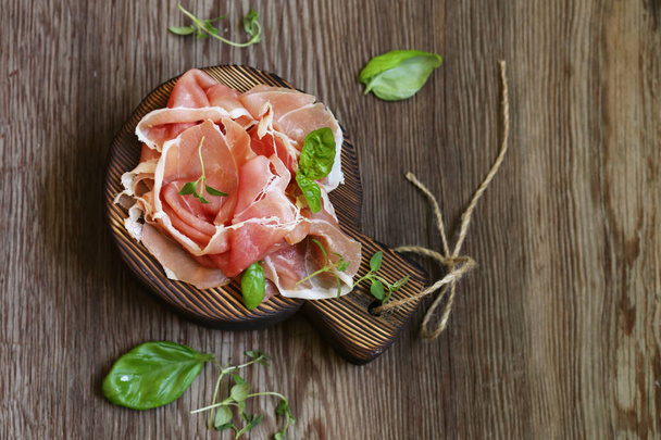 Parma italian dried ham on a wooden board - Foto, imagen