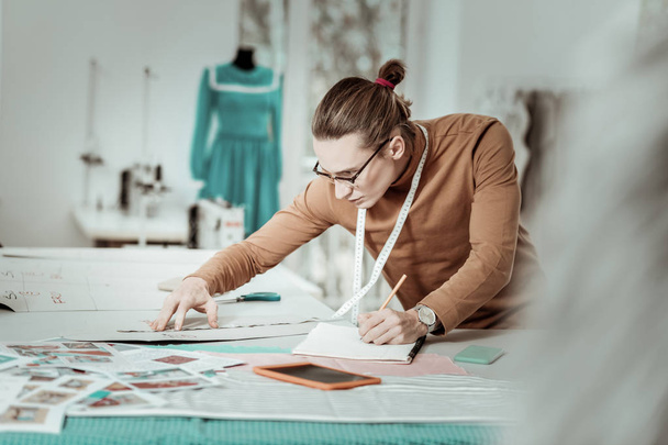Tall long-haired young designer from a fashion school in eyeglasses looking busy - Fotoğraf, Görsel