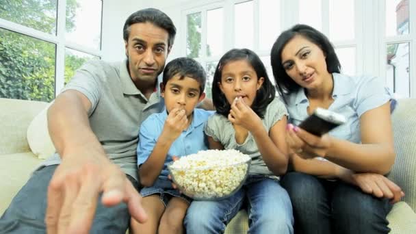 młode rodziny azjatyckie oglądania tv z popcornu - Materiał filmowy, wideo