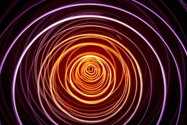 A beautiful, bright light swirl of colors. Futuristic light painting on a black background. Round light circles - Photo, Image