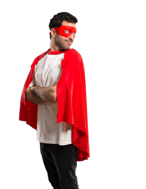 Superhrdina muž s maskou a červené mys v boční poloze při pohledu přes rameno s úsměvem na izolované bílém pozadí - Fotografie, Obrázek
