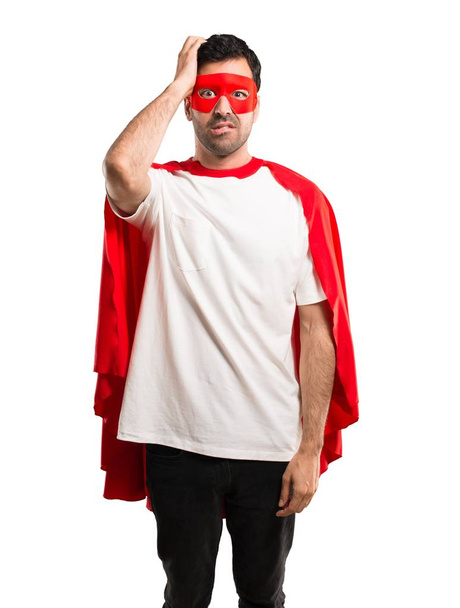 Superheldenmann mit Maske und rotem Umhang, Ausdruck von Frustration und Unverständnis. Verwirrtes Gesten auf isoliertem weißem Hintergrund - Foto, Bild